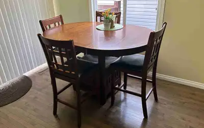 Bar height table and chairs. Table is 60” x 42” or 42” round with leaf removed. Chair top are faux l...