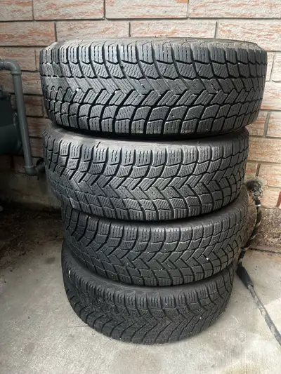 These pre-owned Michelin X-Ice Snow winter tires, size 205/55R16, are mounted on steel rims and are...