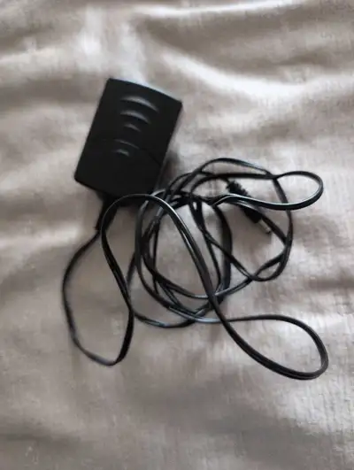 This black AC power adapter is a reliable, pre-owned power solution compatible with various electron...