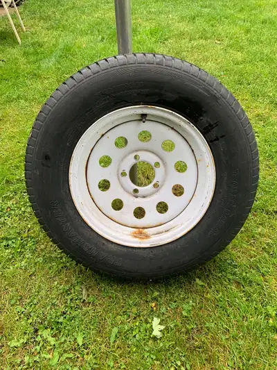 15 inch 5 bolt trailer rim. The rim is in decent shape, but the rubber tire is junk. Asking $10. Pic...