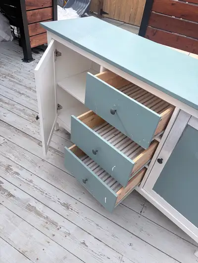 This is a used IKEA sideboard cabinet featuring a light green top and accents, complemented by a whi...