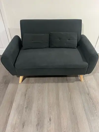 Stylish modern dark green 2-seater loveseat in soft fabric upholstery with light wooden legs. Featur...