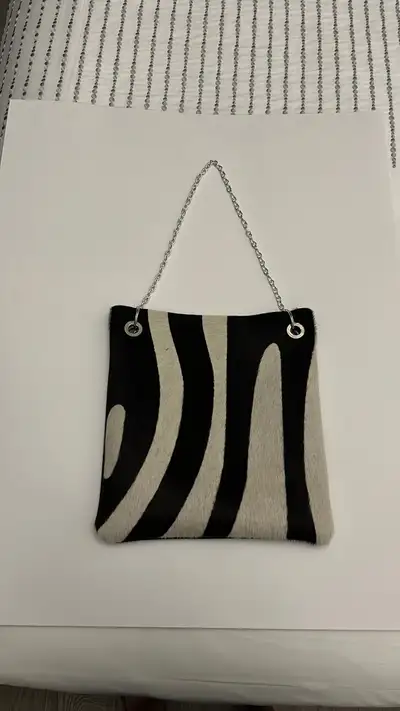 This can be worn as a crossbody bag or if you twist the links into one of the rings and stuff the ex...