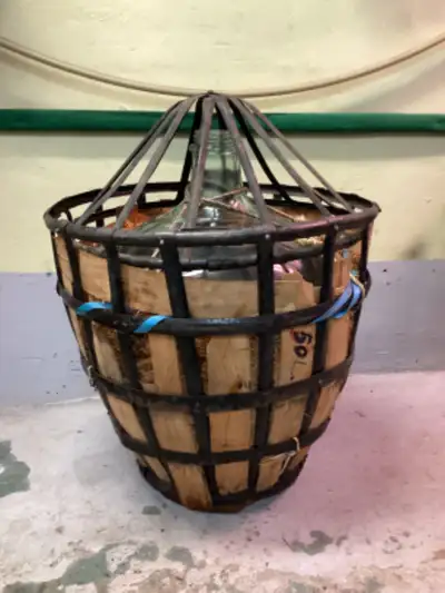 Item très rare. Ancienne cruche en verre entourée de paille dans son panier en métal et son couvercl...
