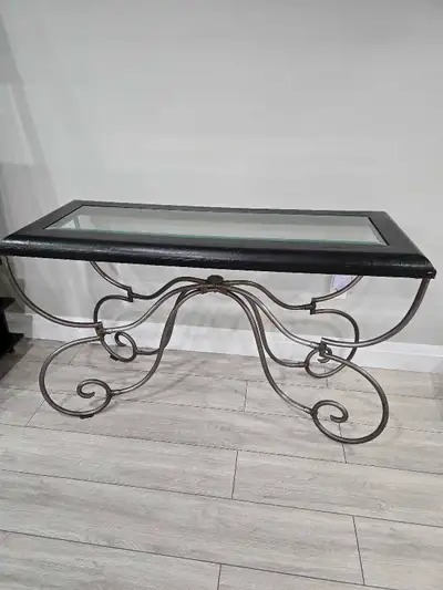 Elevate your living space with this elegant glass top console table! It features a sleek black frame...