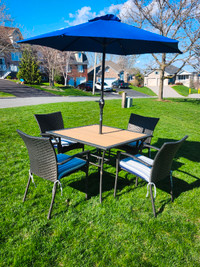 Patio table, umbrella and chairs with cushions.