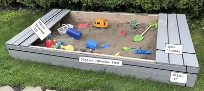 Large sandbox constructed of pressure treated 2x12 beams covered with Trex composite lumber. Coverin...