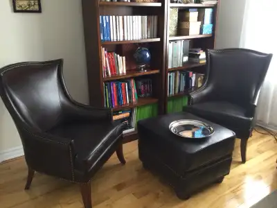 Deux fauteuils et repose pied en cuir