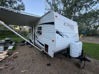 White Cruise Lite Salem travel trailer.there's a dinette and a bathroom with a toilet and shower. In...