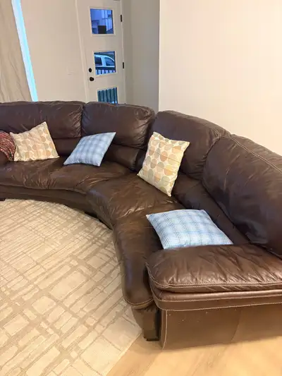 Large curved brown leather sectional sofa in good used condition. Extremely comfortable with deep se...