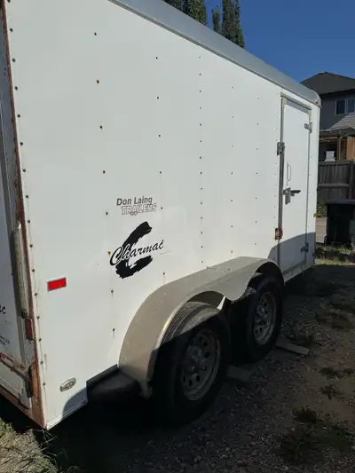 This is a used 6x12 cargo trailer, perfect for hauling equipment or storage. It features a side door...