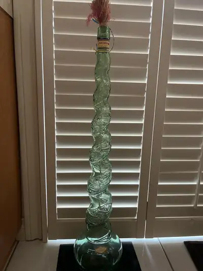 Add a touch of vintage charm to your home with this striking Bardinet green glass decorative bottle!...