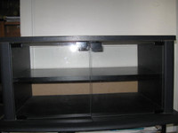 TV table - black finish - clear glass doors - new - $ 50
