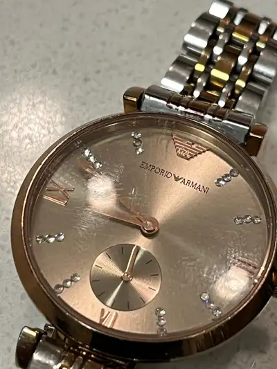Add a touch of elegance to your wrist with this used Emporio Armani women's watch, featuring a styli...