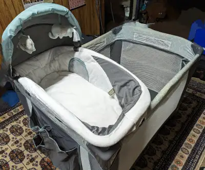 Compact, portable playard with detachable infant cradle can be easily carried to family or friends e...