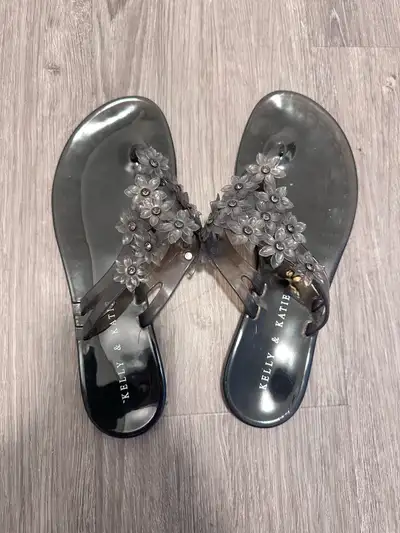 Step into summer with these Kelly & Katie black jelly flip flops, adorned with charming flower accen...