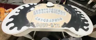 This used Ouija Board Amorier is a unique and spooky piece, featuring custom black and white spirit...