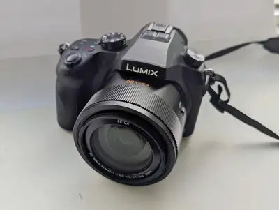 Lumix DMC-FZ1000 bridge camera for sales. Manufacturing year is 2020. Comes with battery, charger an...