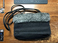 Charcoal grey purse with grey fake fur trim.