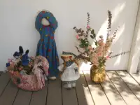 Two dolls & two planters with faux flowers.