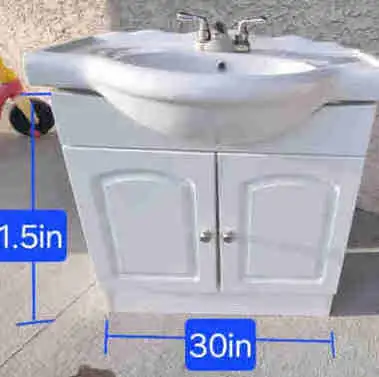 White vanity sink with a two-door cabinet underneath. Dimensions are 30 inches wide and 31.5 inches...