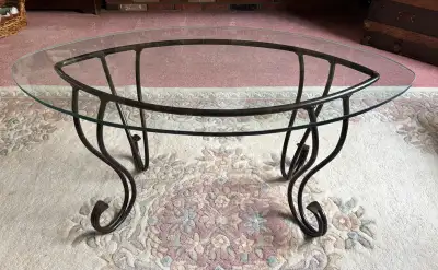 This glass top coffee table features a sleek design with a sturdy metal base, perfect for adding a t...