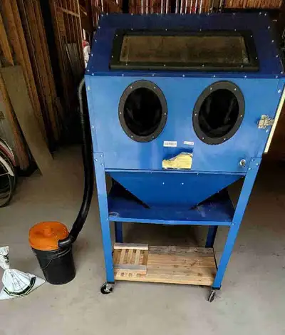 Sand blasting cabinet complete with rolling caster wheels, working light bulbs dust collector bucket...