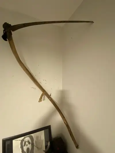 large, long-handled scythe, symbolizing the harvesting of souls., View more