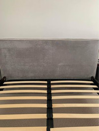 Queen bed with headboard and without mattress and a vacuum clean