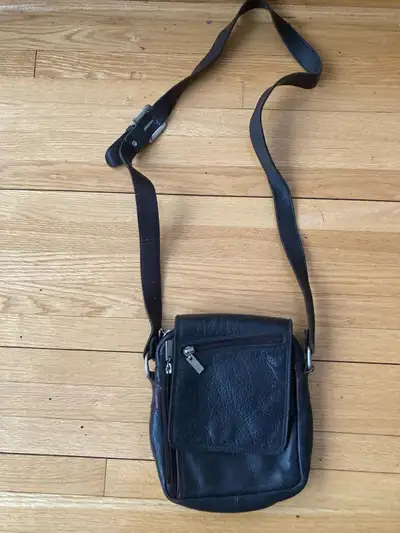 Ce sac bandoulière en cuir noir est parfait pour transporter vos essentiels avec style. Il est en bo...