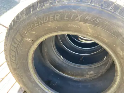 These pre-owned Michelin Defender LTX M/S tires, size LT275/65R18, are designed to provide reliable...