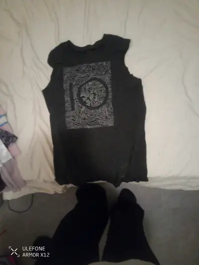 This dark grey tank top features a unique graphic design, perfect for casual wear or as a statement...