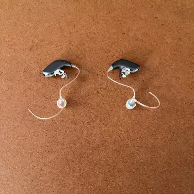 Option Hearing Aids in new condition. Comes with many extra batteries, filters and filter cones stor...