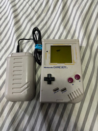 Game Boy and charger missing back cover plate selling as is unte