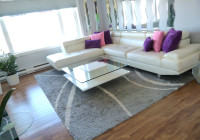 White Faux Leather Sectional, White Coffee Table,  8x10 Area Rug