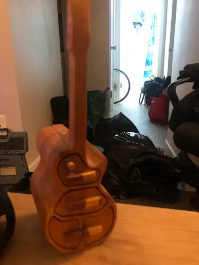 This handcrafted wooden guitar jewelry box features three sliding drawers, offering a unique and cha...