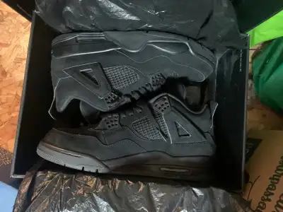 Selling a pair of used Jordan 4 'Black Cat' shoes, known for their sleek design and comfortable fit....