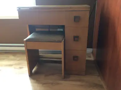 Machine à coudre Singer intégré dans un meuble à 3 tiroirs. Largueur : 17 pouces Hauteur : 31 pouces...