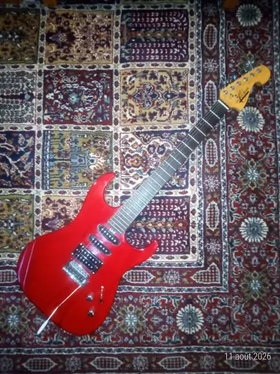 This Oscar Schmidt by Washburn Strat-style electric guitar features a vibrant red finish and a versa...