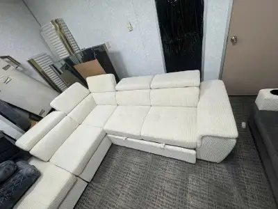 This is a used sectional sofa, featuring a modern design with corduroy upholstery in a creamy white...