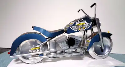 A miniature motorcycle constructed from 51 pieces cut from your favorite recycled beverage cans to p...