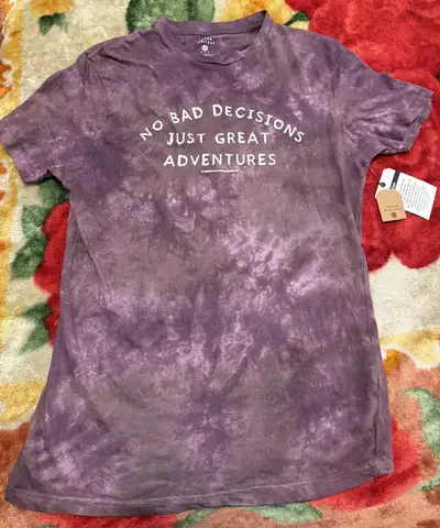 Discover this trendy Urban Heritage tie-dye T-shirt, showcasing a unique purple hue and the playful...