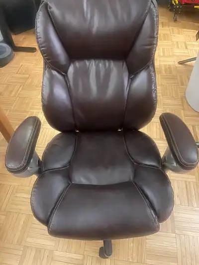 This is a used leather office chair that features a high back design and padded armrests, offering g...