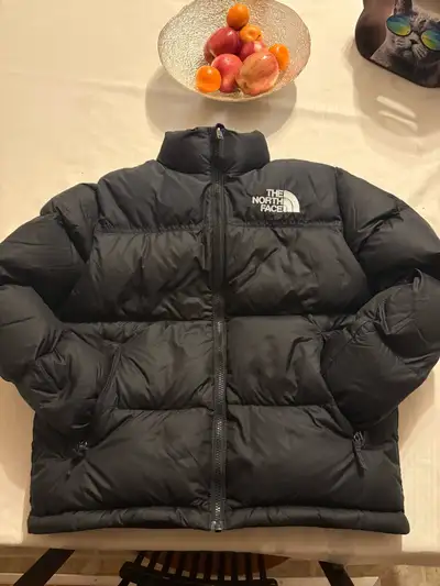This is a stylish black North Face puffer jacket, perfect for keeping your teen warm and cozy! It's...