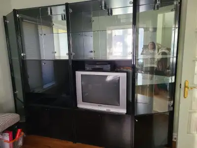 This pre-owned Ikea display cabinet, in good condition, features adjustable glass shelves and integr...