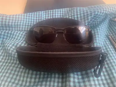 prescription sun glasses and case in park behind Evan Hardy