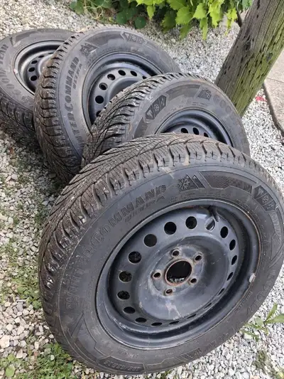 These pre-owned Goodyear WinterCommand Ultra tires, sized 195/65R15, are mounted on black steel rims...