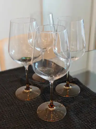 New Mikasa wine glasses with beautiful amber-coloured bases. These glasses are designed with titaniu...
