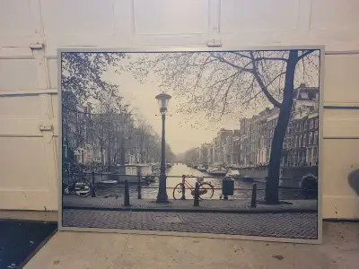 Très grand tableau Ikea dépeignant un vélo rouge au centre d'un pont dans la ville d'Amsterdam. Nous...