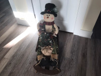 Snowman with wood sleigh with a tree that lights decorations 